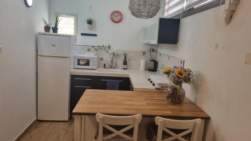a small kitchen with a wooden table and chairs at Luxury peaceful, free parking in Rechovot