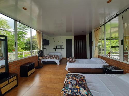 sypialnia z 2 łóżkami i telewizorem z płaskim ekranem w obiekcie Alojamiento Rural Entre El llano y la selva w San José Del Guaviare