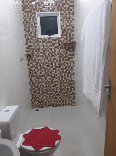 uma casa de banho com WC e uma televisão na parede em chalé caminho da mata em Cavalcante