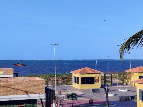 un bâtiment jaune avec l'océan en arrière-plan dans l'établissement Pousada Embarcacao, à Tutóia