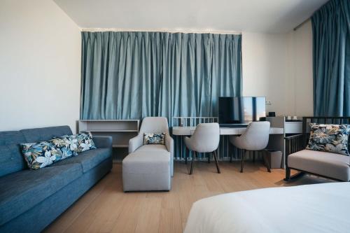 a living room with a couch and a table and chairs at Elements Hotel & Shops Curaçao in Willemstad