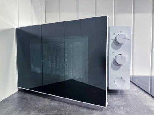a microwave oven with a glass door on a wall at Panorama View - FREE Parking - PERFECT For Couples in Tromsø