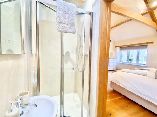 a bathroom with a shower and a sink next to a bed at Budding - Uk4269 in Dyrham