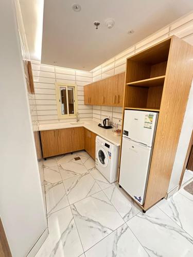 uma cozinha com um frigorífico e uma máquina de lavar e secar roupa em منازل اليتا em Ar Rabwah