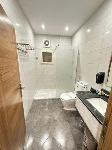 a bathroom with a shower and a toilet and a sink at درة الينا للشقق المخدومة in Ar Rabwah