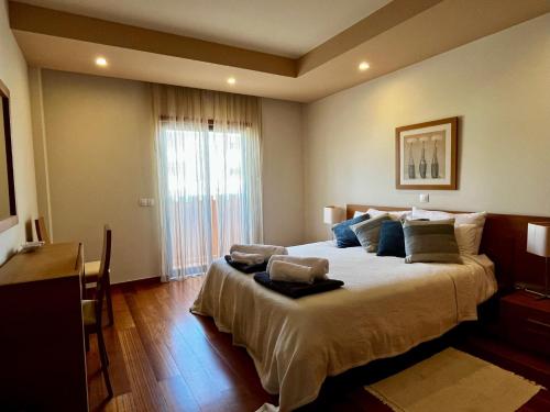 - une chambre avec un grand lit et une grande fenêtre dans l'établissement E&M Apartment Luz, à Luz