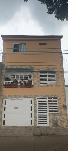 a building with two white garage doors on it at Apartamento amoblado nuevo en Guadalajara de Buga in Buga