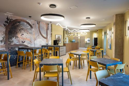 a dining room with tables and yellow chairs at Hotel Aldama in Merida