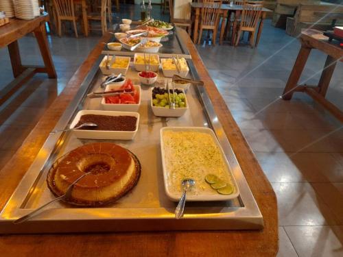 un largo buffet de comida en una mesa en Apartamento Quartier no Parque Aldeia das Aguas, en Barra do Piraí