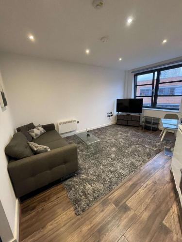 a living room with a couch and a flat screen tv at One Bedroom Apartment/Studio in Birmingham