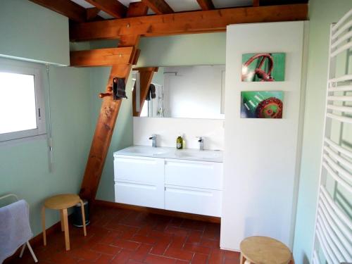 La salle de bains est pourvue d'un lavabo blanc et d'un plafond en bois. dans l'établissement Maison familiale 8 personnes à 100m de la plage avec jardin et parking - FR-1-639-38, à Arzon