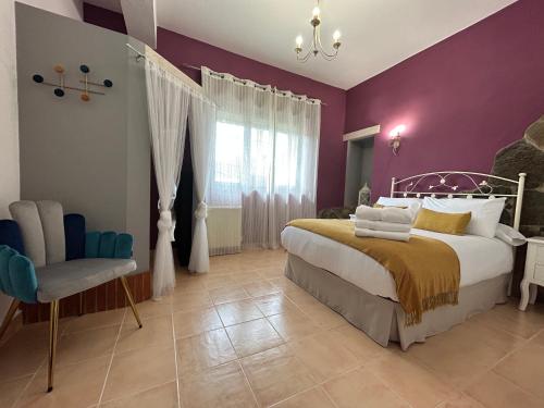 een slaapkamer met paarse muren en een bed en een stoel bij El valle de Lis in Praves
