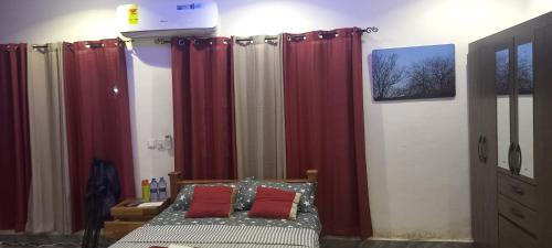 a bedroom with a bed with red curtains at OGK, Ghana in Accra