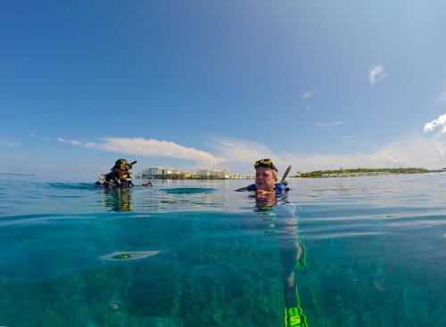 a man is in the water in the ocean at Aveyla Manta Village in Dharavandhoo