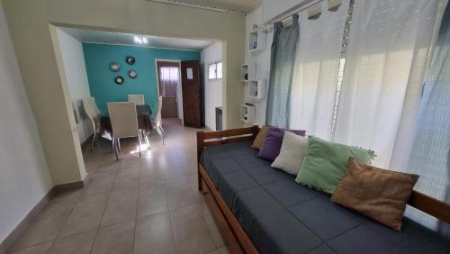 ein Wohnzimmer mit einem Sofa mit Kissen darauf in der Unterkunft Hospedaje "LUZ" in Olavarría