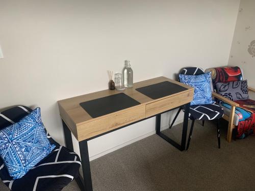einen Holztisch mit zwei Stühlen in einem Zimmer in der Unterkunft KG Ensuite in Palmerston North