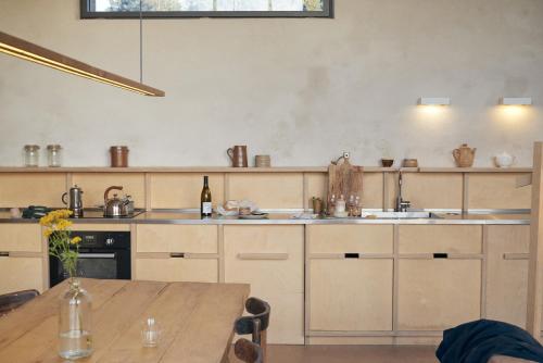 a kitchen with wooden cabinets and a wooden table at La Ferme de Brouage - GIte #3 in La-Gripperie-Saint-Symphorien
