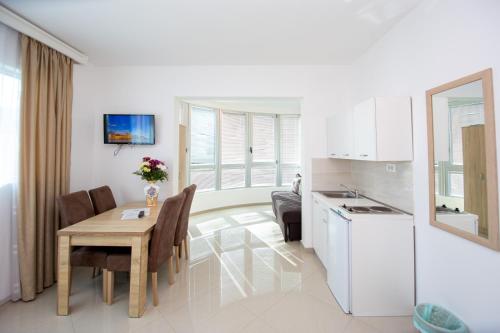 uma cozinha e sala de jantar com uma mesa e uma sala de jantar em Apartments Blanco em Budva