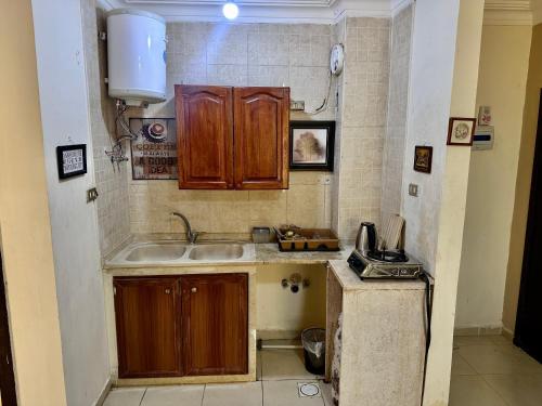a small kitchen with wooden cabinets and a sink at DeadSea Accommodation with AC in Sowayma