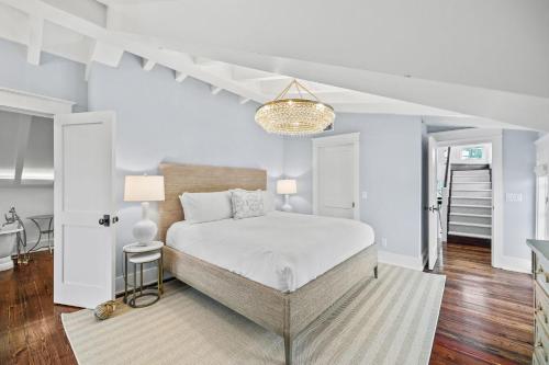 a white bedroom with a bed and a staircase at Our Happy Place in Santa Rosa Beach