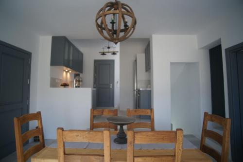 a dining room with a table and chairs and a chandelier at Krotiri View Paros in Krotiri