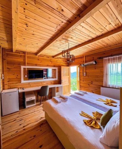 ein Schlafzimmer mit einem großen Bett in einem Holzzimmer in der Unterkunft disharoyaylaevleri in Meşeli