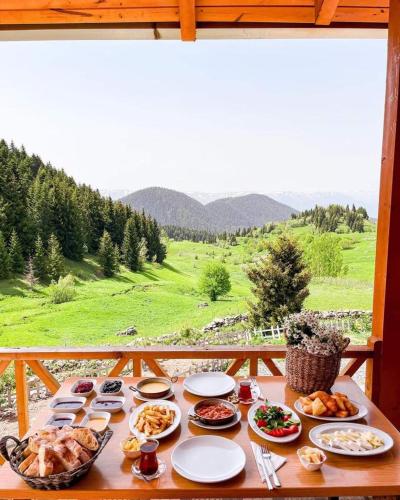 a table with food on it with a view of a field at disharoyaylaevleri in Meşeli