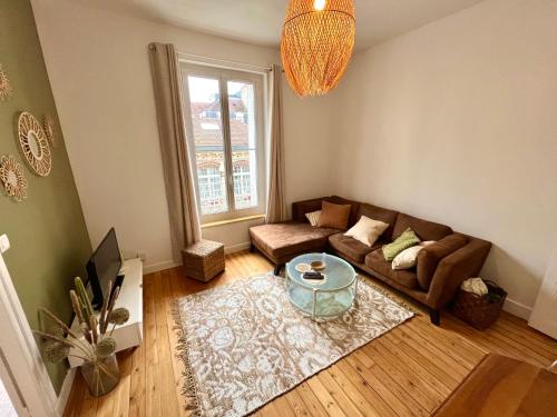 - un salon avec un canapé et une table dans l'établissement Appartement entier en plein coeur du centre ville, à Compiègne