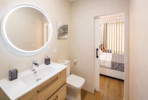 a bathroom with a sink and a mirror and a bed at Suite Puerto Banus con piscina in Marbella