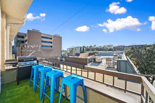 a row of blue stools on a balcony with a grill at Beverly Hills Penthouse 2 BR Apt with Parking 407 in Los Angeles