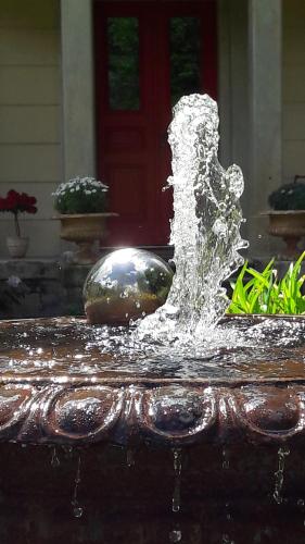a water fountain in front of a house at Parkresidenz Flora in Schweizermühle