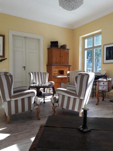 a living room with three chairs and a piano at Parkresidenz Flora in Schweizermühle
