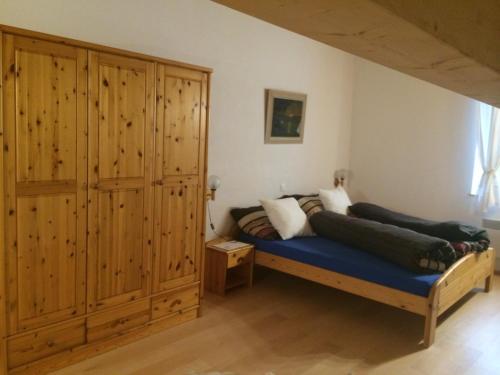a bedroom with a bed and a large wooden cabinet at Osteria Del Centro in Brusio