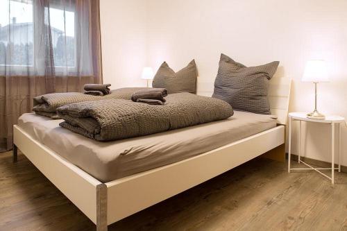 um quarto com uma cama com almofadas em Apartment Schafbergblick mit Balkon ID 8607747 und Apartment Himmelspforte mit Balkon ID 8607779 em Mondsee