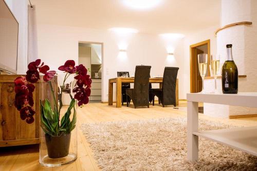 uma sala de estar com uma mesa e um vaso com flores em Apartment Schafbergblick mit Balkon ID 8607747 und Apartment Himmelspforte mit Balkon ID 8607779 em Mondsee