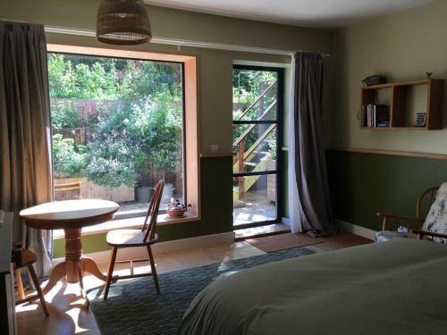 une chambre avec un lit, une table et une fenêtre dans l'établissement The Green Room. South Derbyshire, à Derby