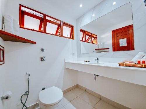 a white bathroom with a sink and a toilet at Pousada João Fernandes in Búzios