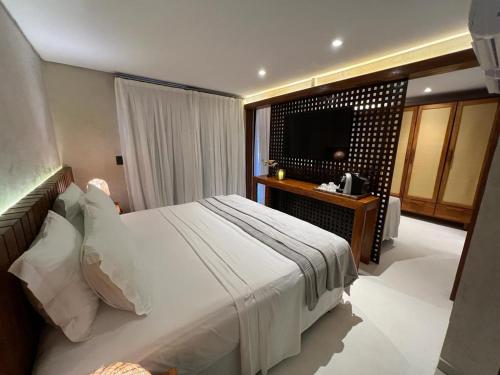 a bedroom with a large bed and a television at Pousada Naonda in Fernando de Noronha