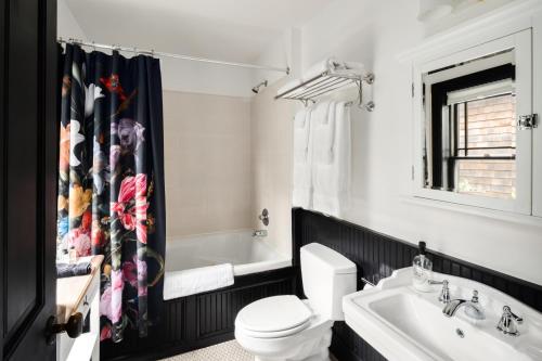 a bathroom with a toilet and a sink at Hotel Mountain Brook in Tannersville