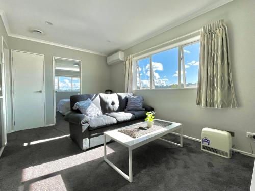 a living room with a couch and a table at Albany Modern Private 2 bedroom 2 bathroom with Full Kitchen Netflix in Auckland