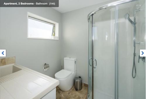 a bathroom with a toilet and a glass shower at Albany Modern Private 2 bedroom 2 bathroom with Full Kitchen Netflix in Auckland