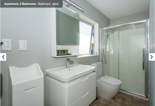 a white bathroom with a sink and a toilet at Albany Modern Private 2 bedroom 2 bathroom with Full Kitchen Netflix in Auckland