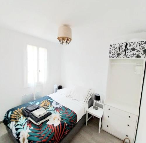 une chambre blanche avec un lit et une commode dans l'établissement Artists Apartment Montpellier-Place de la Comédie, à Montpellier