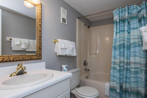 a bathroom with a sink and a toilet and a mirror at Island Shores 654 in Gulf Shores