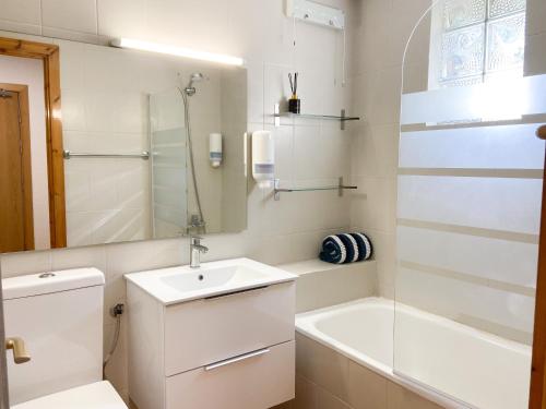 een witte badkamer met een wastafel en een bad bij Ático Dúplex Con Increibles Vistas a La Valle De Incles - Parking Gratis in Incles