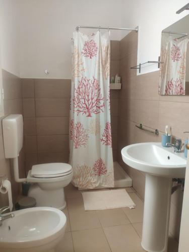 La salle de bains est pourvue de toilettes, d'un lavabo et d'un rideau de douche. dans l'établissement Zia Mary, à Solarino