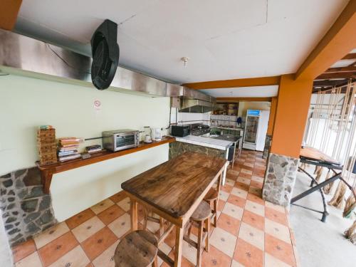 uma cozinha com uma mesa de madeira num quarto em Hostel de Haan em Jacó