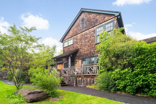 an old brick house with a large deck at Hotel Mountain Brook in Tannersville