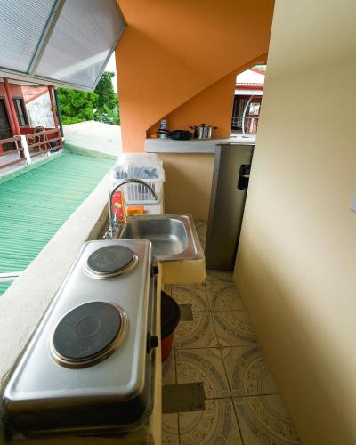 a small kitchen with a sink and a sink at Hostel de Haan in Jacó