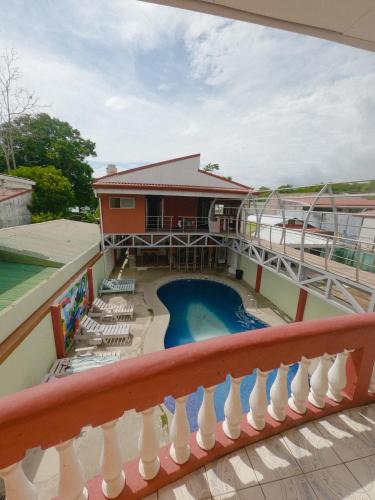 a view from the balcony of a house with a swimming pool at Hostel de Haan in Jacó